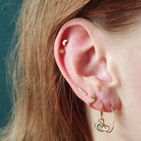 Goudkleurige barbell piercing van chirurgisch staal met goldplated afwerking en bar design met zirconia steentjes. De strakke vorm met subtiele sparkle zorgt voor een moderne en stijlvolle uitstraling. Geschikt voor diverse oorpiercings.